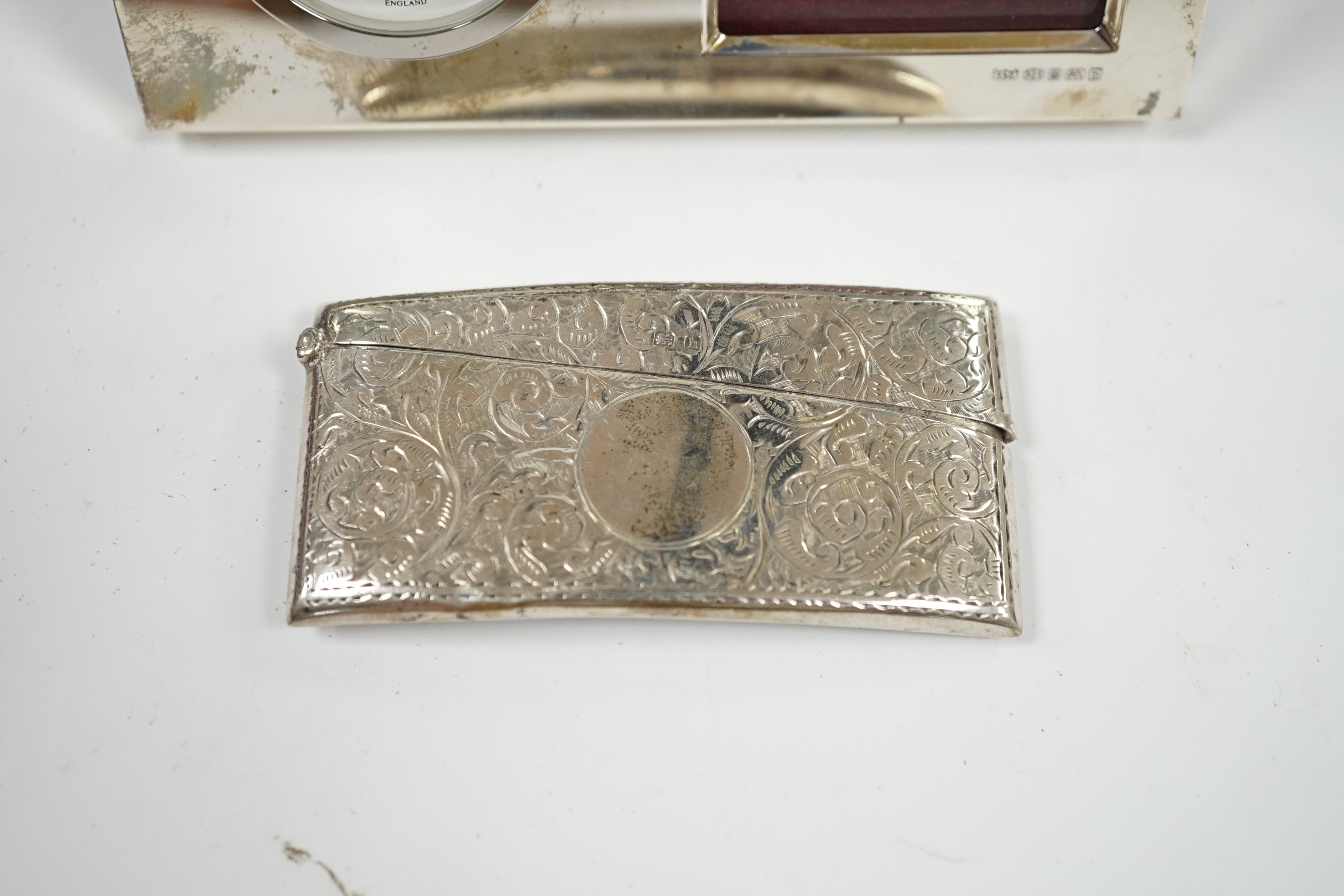 An Edwardian engraved silver card case, Birmingham, 1907, 82mm and a modern silver desk timepiece. Condition - poor to fair